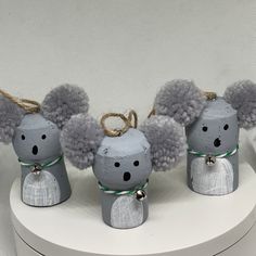 three little gray mouses sitting on top of a white table