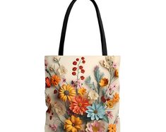 a tote bag with flowers painted on the front and side, in multicolored colors