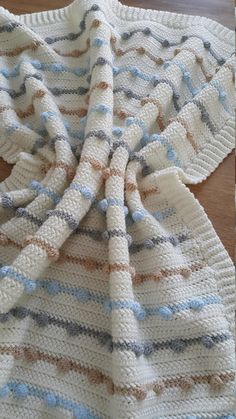 a crocheted blanket sitting on top of a wooden table