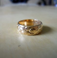 This band ring is handcrafted from 14k gold filled heavy pattern wire.The pattern makes it eye-catching. Unusual and fancy for a heavy weight band. It is a heavy band, 6.4mm wide and 1.7mm thick.This ring makes a great wedding band for either him or her. Couple it with my 4mm pattern ring to make a great wedding band set. http://www.etsy.com/listing/65984697/4mm-pattern-band-ring-14k-gold-filled---------------------------------DIMENSIONS: 6.4mm wide and 1.5mm thick.------------------------------ Gold Thick Band Jewelry For Promise, Gold Engraved Thick Band Ring For Promise, Gold Engraved Ring With Thick Band For Promise, Gold Engraved Wide Band Ring For Promise, Gold Wide Band Engraved Promise Ring, Gold Decorative Band Promise Ring, Gold Engraved Wide Band Ring Hallmarked, Gold Engraved Ring With Hallmarked Wide Band, Gold Bands With Intricate Design For Gifts