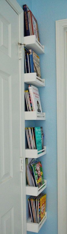 there is a book shelf in the corner of this room with blue walls and white doors