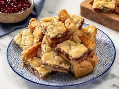 a pile of cranberry bars on a blue and white plate