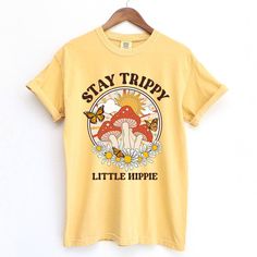 Stay Trippy Little Hippie Short Sleeve T-shirt is made of Comfort Colors material with an oversized fit. Show off your boho vibes with a groovy mushroom graphic and hippie soul design. Perfect for a relaxed summer look. Cheap Groovy Graphic Print T-shirt, Cheap Groovy Graphic T-shirt, Cheap Hippie Style Screen Print T-shirt, Cheap Groovy Cotton T-shirt, Groovy Mushroom, Tshirt 2023, Stay Trippy Little Hippie, Hippie Shorts, Mushroom Graphic