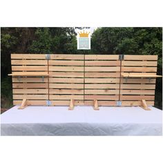 a wooden fence made out of pallets on top of a white cloth covered table