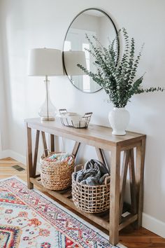 a wooden table with two baskets and a mirror