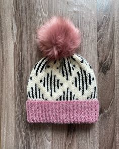 This warm double-brimmed hat is fitted and sits snugly on your head. Perfect for keeping you warm in the winter. The hat was made by me from 80% acrylic, 20% wool yarn in a pet-free and smoke-free home. This hat also features a pink faux fur pom pom. Care: Hand wash and lay flat to dry. These items are handmade and, as such, minor imperfections are to be expected. Crochet Colorwork, White Beanie, Pink Beanie, Crochet Pink, Lion Brand Wool Ease, Rose Noir, White Beanies, Handmade Knitwear, Aran Weight Yarn