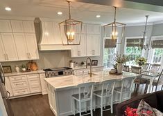 a large kitchen with white cabinets and an island in the middle of the living room