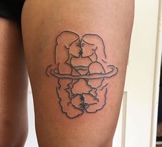 a woman's thigh with a tattoo of two women holding each other on it