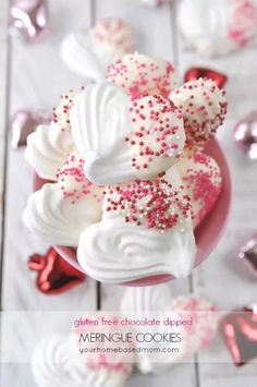 white chocolate dipped meringue cookies with pink sprinkles on a plate