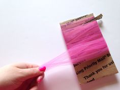 a person holding a piece of pink fabric