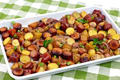 a white dish filled with potatoes on top of a green and white checkered table cloth