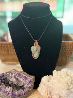 One of a kind tumbled and polished green stone hand wrapped in copper wire. Perfect gift for anyone who appreciates precious stones and one-of-a-kind jewelry. No two pendants are alike! Benefits of Wearing Copper Jewelry: It's known to help reduce inflammation, arthritis, headaches, and improve digestions. It helps bring the body into alignment. It amplifies energy and is an excellent conductor that helps stimulate the flow of energy. If you have any questions, please message me on here. Thank you for your time and have a wonderful day! Green Copper Hand Wrapped Necklaces, Green Hand Wrapped Copper Necklace, Amazonite Wire Wrapped Necklaces As Gift, Green Wire Wrapped Copper Wire Necklaces, Just Because Gifts, Hand Wrap, Reduce Inflammation, Green Stone, Copper Jewelry