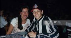 two people sitting at a table smiling for the camera