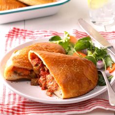 the sandwich is cut in half and ready to be eaten on the plate with salad