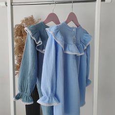 two shirts hanging on a clothes rack next to a teddy bear