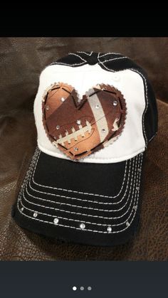 a black and white baseball cap with a heart cut out of it