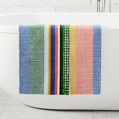 a colorful towel is hanging on the edge of a bathtub