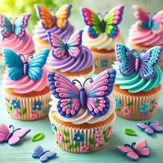 cupcakes decorated with butterflies and flowers on a table