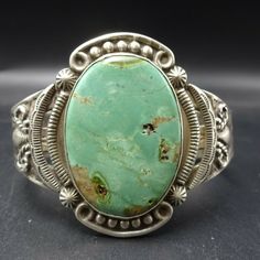 "VINTAGE NAVAJO BRACELET DESCRIPTION: This wonderful Harvey Era cuff features extensive stampwork and a huge specimen of gorgeous light green variscite. This bracelet will be a cherished addition to your collection of fine vintage Native American jewelry. MEASUREMENTS: Interior of the cuff measures 5 1/4\" with an additional 1 1/4\" slightly adjustable gap. Total circumference: 6 1/2\" Measures 2 1/2\" straight across the widest part (from wrist bone to wrist bone) Bracelet face measures 1 3/4\" Southwestern Engraved Green Jewelry, Southwestern Style Engraved Green Jewelry, Green Bohemian Bracelets With Patina, Artisan Green Cuff Bangle Bracelet, Adjustable Southwestern Green Cuff Bracelet, Vintage Green Bracelet With Patina, Southwestern Green Bangle Jewelry, Adjustable Green Southwestern Cuff Bracelet, Southwestern Style Green Bangle Jewelry