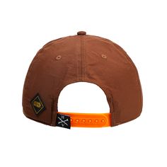 a brown hat with an orange band around the brimmed visor and two patches on it