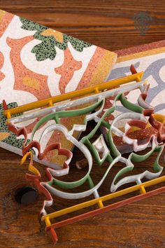 a close up of a decorative object on a wooden table with an orange and green design