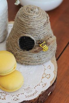 two macaroons are sitting on a table next to a beehive