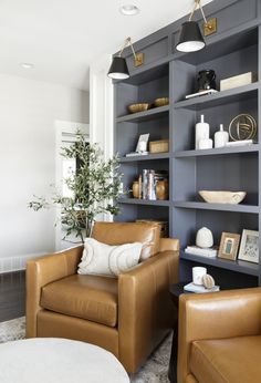 a living room filled with lots of furniture and bookshelves covered in brown leather