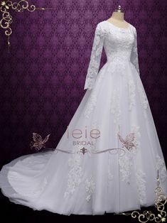 a white wedding dress with long sleeves and lace on the skirt is displayed in front of a