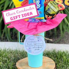 a blue container filled with candy sitting on top of a tree stump in the grass