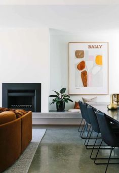 a living room filled with furniture and a fire place next to a painting on the wall