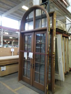 an open glass door in a warehouse with lots of wood and other items on the floor