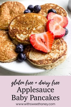 pancakes with strawberries and blueberries are on a white plate