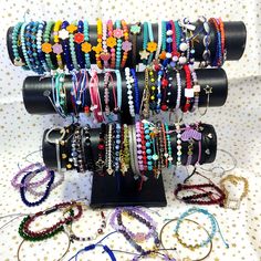 there are many bracelets that are on the stand and all have different colored beads