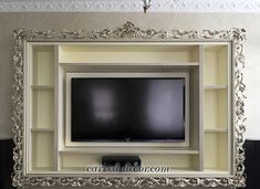 a large tv mounted to the side of a white wall in front of a mirror