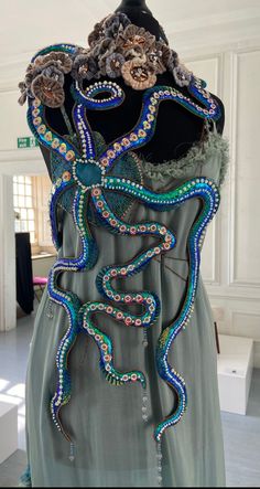 a dress made out of beads and fabric with an octopus design on it's back