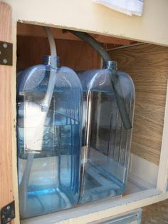 three blue water bottles are sitting in a cabinet