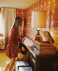 a woman standing in front of a table with a record player on top of it