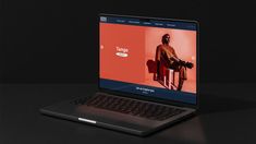 an open laptop computer sitting on top of a black table in front of a dark background