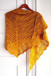 a yellow crocheted shawl hanging on a door handle with the words florin triangle written below it