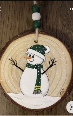 a wooden ornament with a snowman painted on it