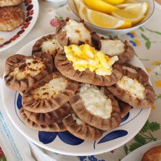 there are many small pastries on the plate and some lemons in the bowl