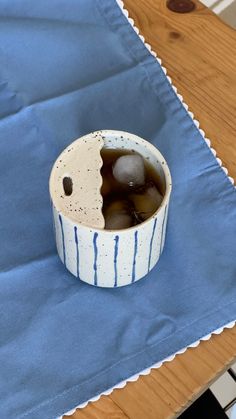 a bowl with ice in it sitting on top of a blue cloth covered tablecloth