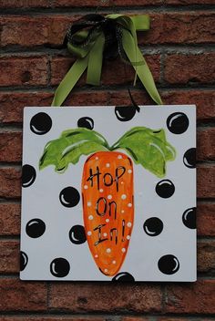 a painted carrot hanging on a brick wall