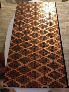 a table made out of coins sitting on top of a tiled floor