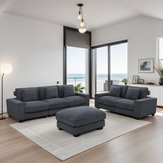 a living room with two couches and a chair in front of a large window