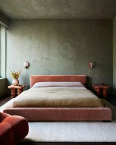 a large bed sitting next to a window in a bedroom on top of a white rug