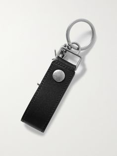 a black leather keychain with a silver metal button on it's side