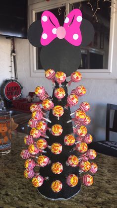 a minnie mouse cupcake tower with lollipops in it's center