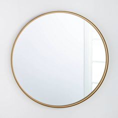 a round mirror hanging on the wall