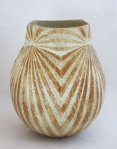 a brown and white vase sitting on top of a table